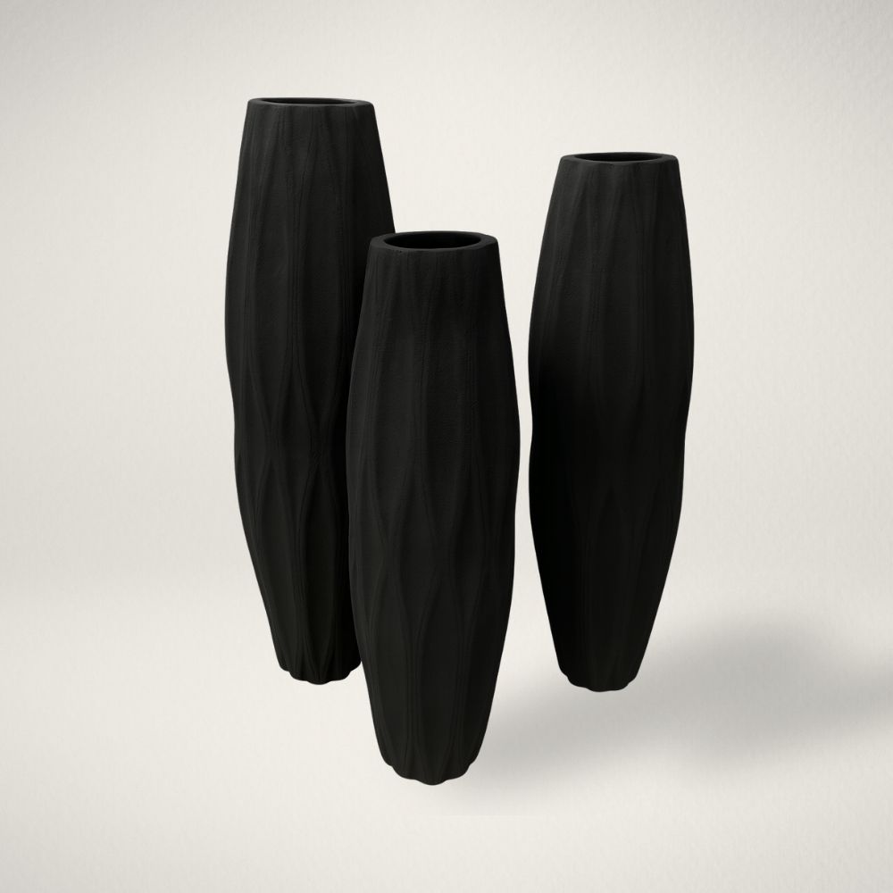 MD TRELLIS Set of three tall matte black vases with organic carved texture and sculptural, elongated silhouettes.