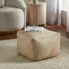 Square pouf in soft beige fabric with a casual, structured design.