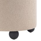 Round beige pouf with textured upholstery and rounded black feet.