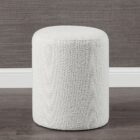 Round ivory pouf with soft textured upholstery.