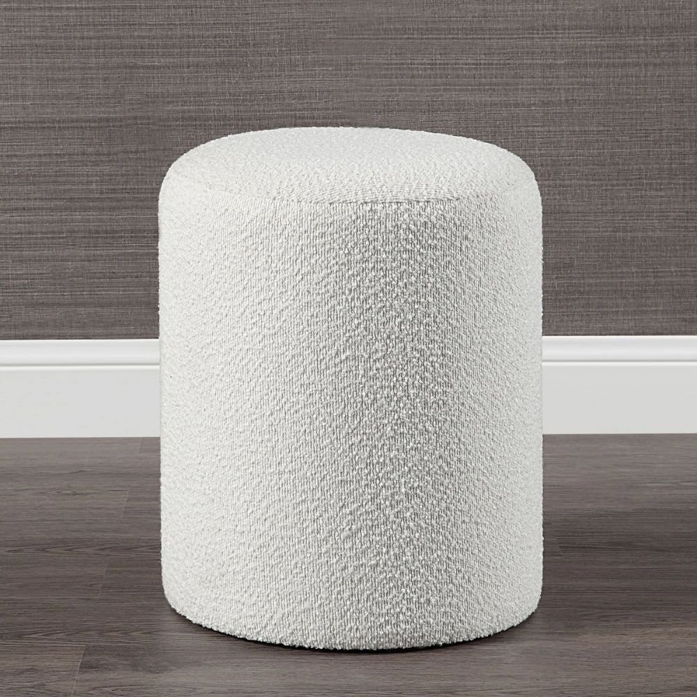 Round ivory pouf with soft textured upholstery.