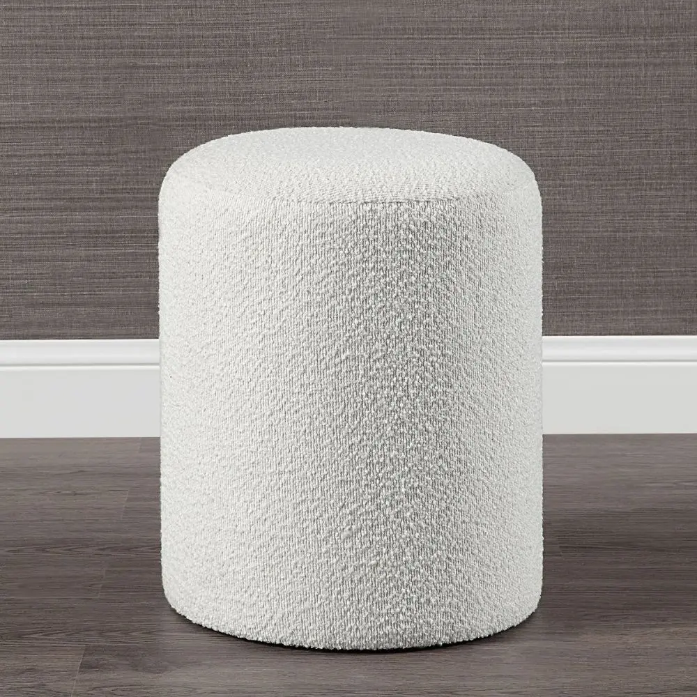 Round ivory pouf with soft textured upholstery.