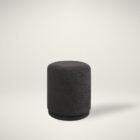 Round black pouf with sleek fabric upholstery.