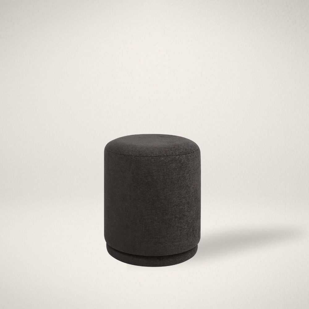 RN HEVEA Round black pouf with sleek fabric upholstery.