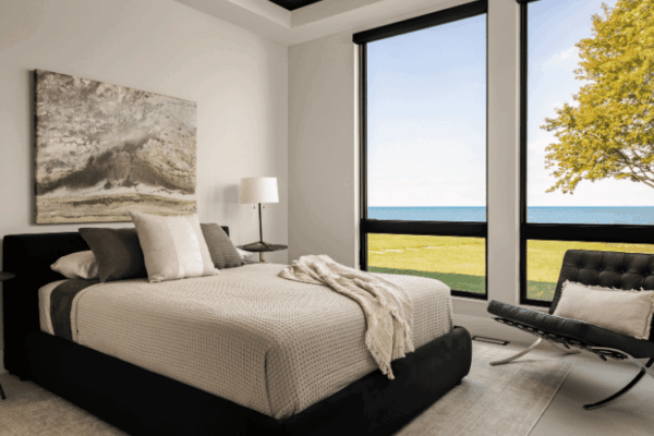 Modern bedroom with floor-to-ceiling windows overlooking Lake St Clair designed by Urbanhome Interior Design