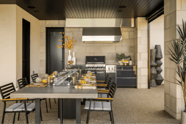 Covered outdoor dining area with built-in barbecue kitchen designed for entertaining at the Modern Manor on Lake St Clair