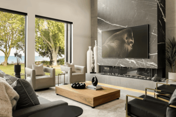 Modern living room with marble fireplace feature wall and lakefront views in The Modern Manor designed by Urbanhome Interior Design