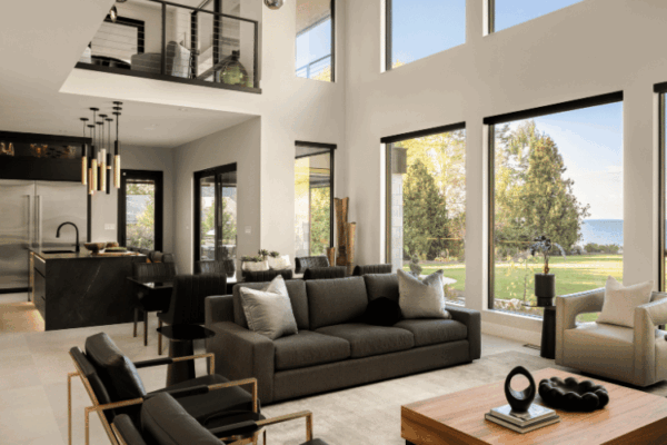 Open concept luxury living room and kitchen with floor-to-ceiling windows overlooking Lake St Clair designed by Urbanhome Interior Design