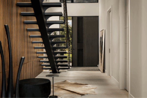 Modern floating staircase with wood slat feature wall in luxury foyer designed by Urbanhome Interior Design in Windsor Ontario