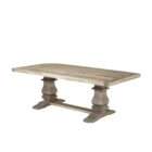 Rectangular wood dining table with a thick top, carved pedestal legs, and a horizontal stretcher base in a soft grey-brown finish.