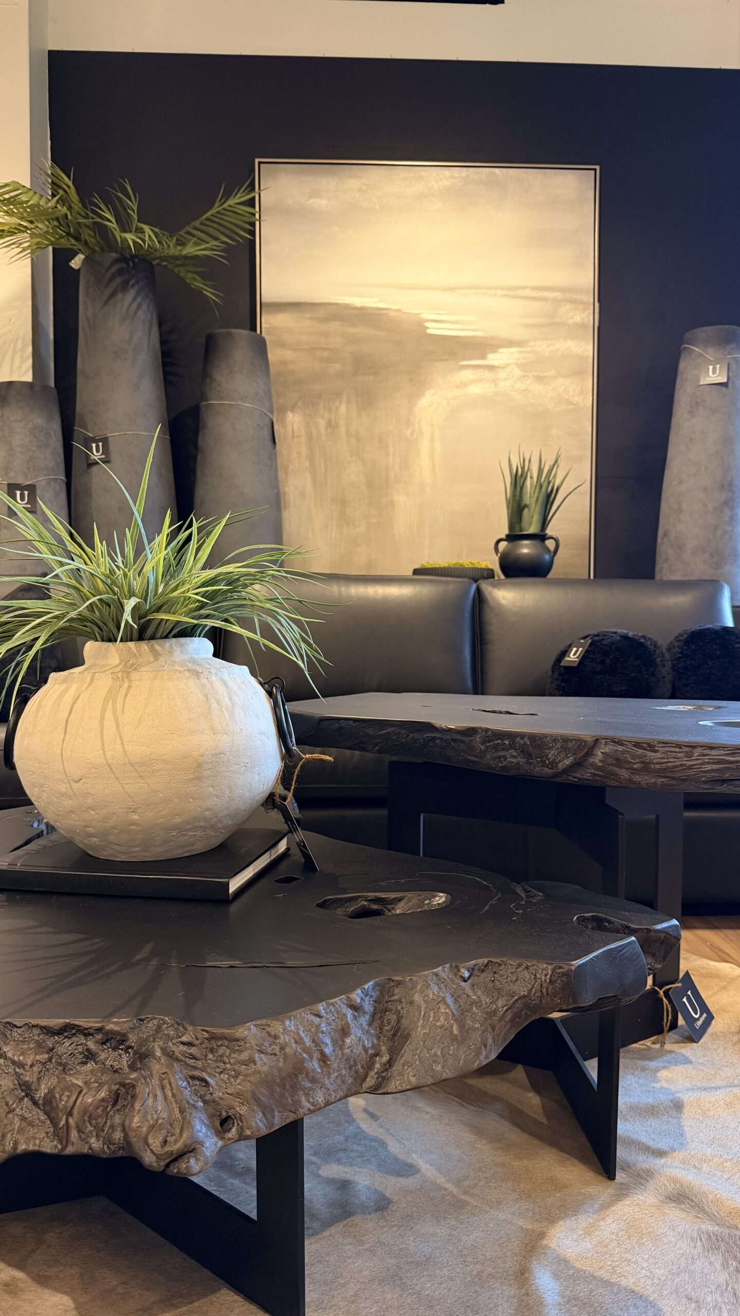 Luxury black wood coffee tables and modern designer furniture displayed in a moody contemporary interior showroom at Urbanhome Interior Design in Windsor Ontario.