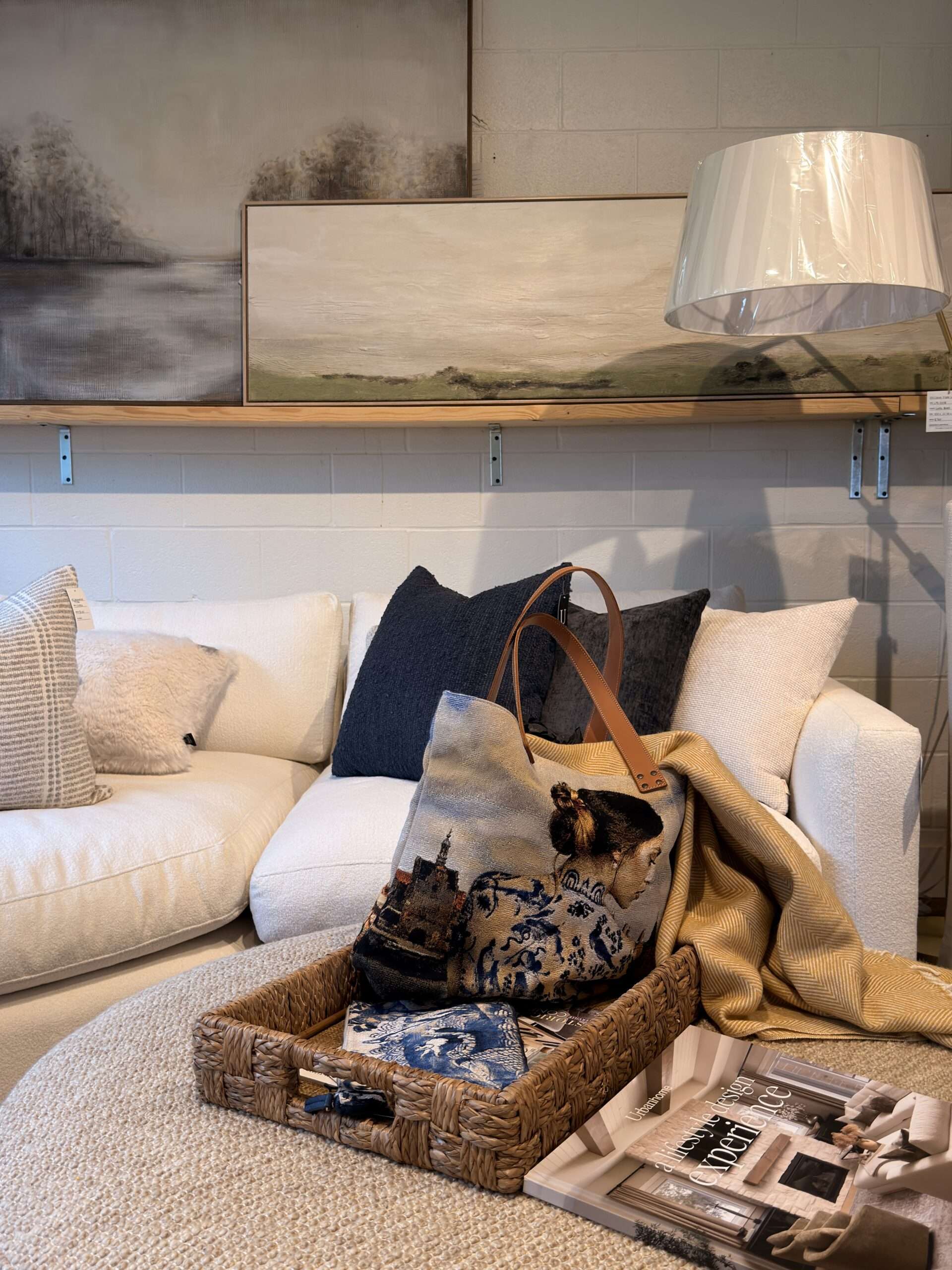 Neutral luxury sofa styled with layered designer pillows, textured décor, and curated accessories in a modern interior showroom.