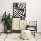 Modern black wood accent chair with woven cane back and neutral upholstered seat.