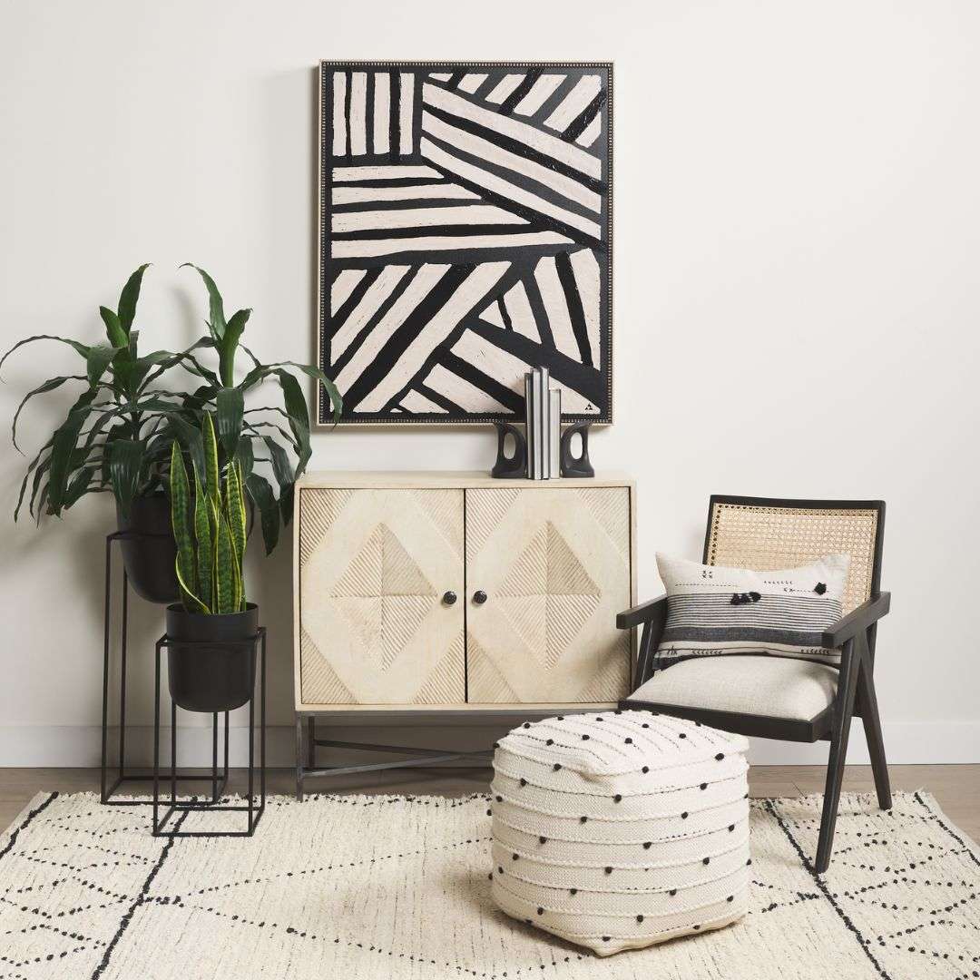 Modern black wood accent chair with woven cane back and neutral upholstered seat.