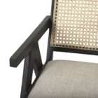 Modern black wood accent chair with woven cane back and neutral upholstered seat.