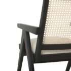 Modern black wood accent chair with woven cane back and neutral upholstered seat.