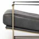 Modern black leather accent chair with sleek brass metal frame and minimalist silhouette.