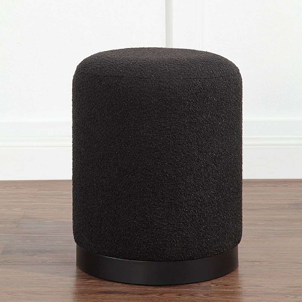 Renwil Castillo ottoman in dark textured upholstery with cylindrical shape and black base