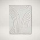 Cream textured area rug with raised geometric patterns and subtle fringe detailing along the edges.