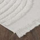 Cream textured area rug with raised geometric patterns and subtle fringe detailing along the edges.