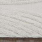 Cream textured area rug with raised geometric patterns and subtle fringe detailing along the edges.