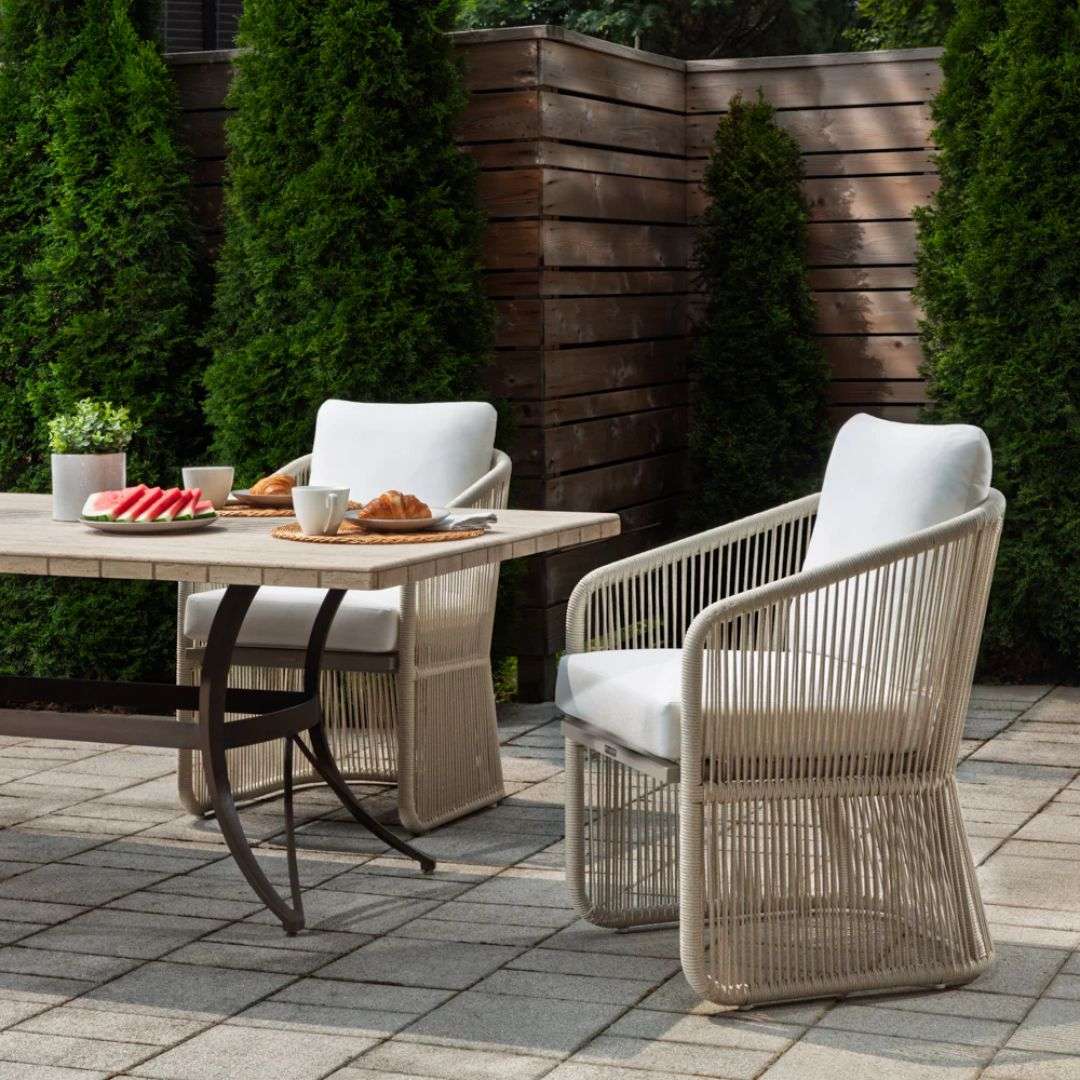 Outdoor lounge chair with woven rope sides in a soft neutral tone, featuring a light frame and plush white seat and back cushions.