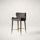 Modern counter stool with taupe upholstered seat, black quilted back detail, and black metal legs with brass accents.