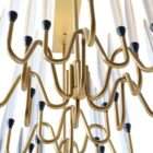 Modern linear chandelier with brass frame and multiple candle-style lights arranged in a sculptural wave pattern.