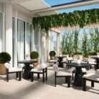 Round black side table with a sculptural pedestal base and minimalist design.