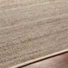 Neutral beige woven area rug with subtle tonal variation and organic texture.