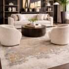 Abstract area rug with layered gold, taupe, and grey tones creating an artistic, textured pattern.