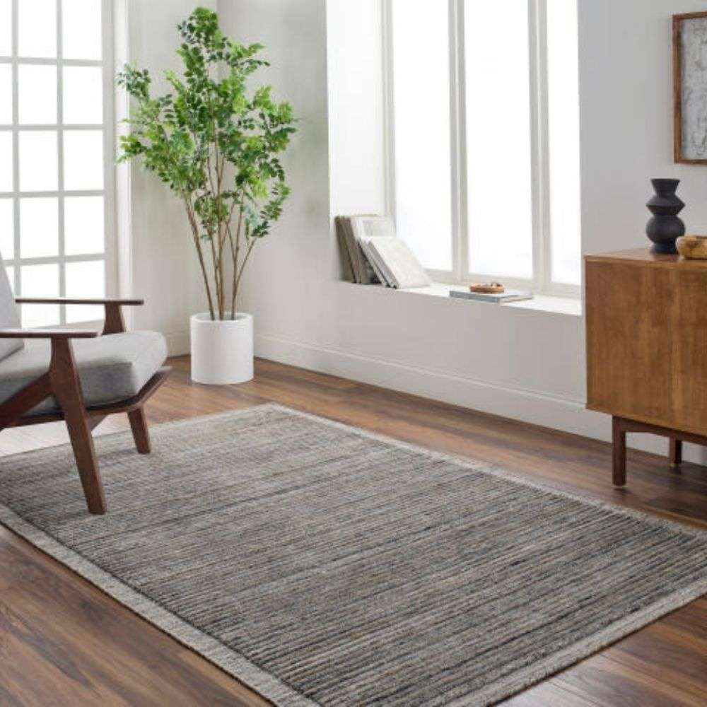 Textured area rug in layered grey and brown tones with subtle horizontal striations.