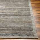 Textured area rug in layered grey and brown tones with subtle horizontal striations.