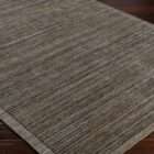 Textured area rug in layered grey and brown tones with subtle horizontal striations.