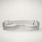 Curved sectional sofa in a soft neutral fabric with a low profile, rounded arms, and plush seating, accented with patterned throw pillows.