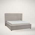 Upholstered bed with a tall channel-tufted headboard, soft neutral fabric, and a low-profile frame.