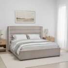 Upholstered bed with a tall channel-tufted headboard, soft neutral fabric, and a low-profile frame.