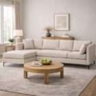 Grey upholstered sectional sofa with chaise, clean lines, plush cushions, and slim black metal legs.