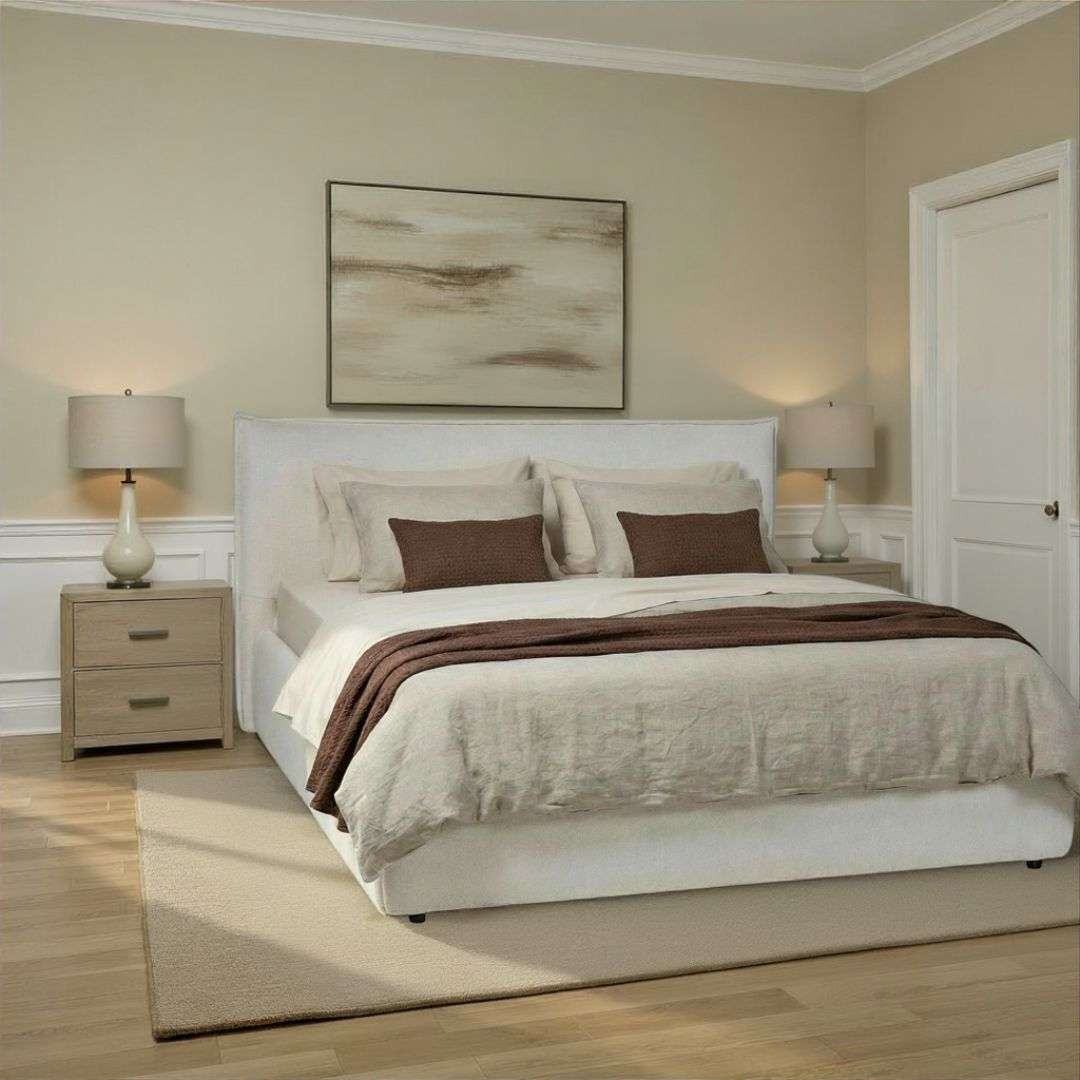 Fully upholstered bed with a clean-lined headboard, soft neutral fabric, and a low-profile frame.