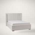 Upholstered bed with a tall vertical channel-tufted headboard, soft textured fabric, and a low-profile frame.