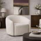 Curved swivel accent chair in soft ivory textured upholstery with a rounded back and compact seat.