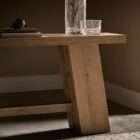Minimalist wood console table with a rectangular top, angled plank legs, and a lower stretcher in a light natural finish.
