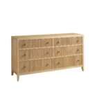 Light wood dresser with six drawers featuring vertical fluted detailing and round metal knobs.