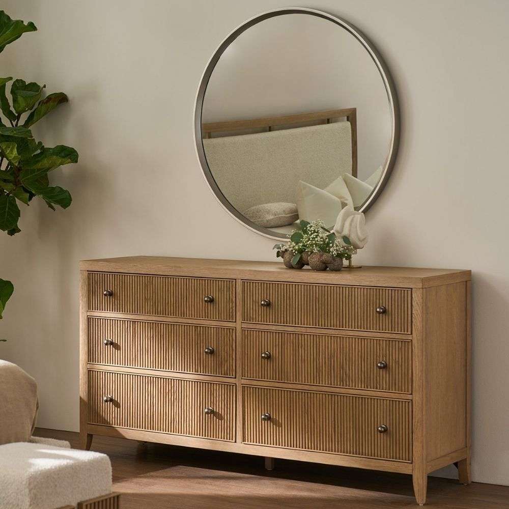 Light wood dresser with six drawers featuring vertical fluted detailing and round metal knobs.