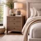 Wood nightstand with three drawers, vertical fluted detailing, and a warm natural finish with round metal knobs.