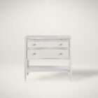 White nightstand with two drawers, slim legs, brass-accented hardware, and an open lower shelf.
