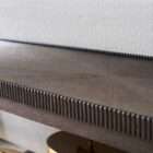 Long wooden console table with a lower shelf, curved legs, and detailed edge trim in a warm medium wood finish.