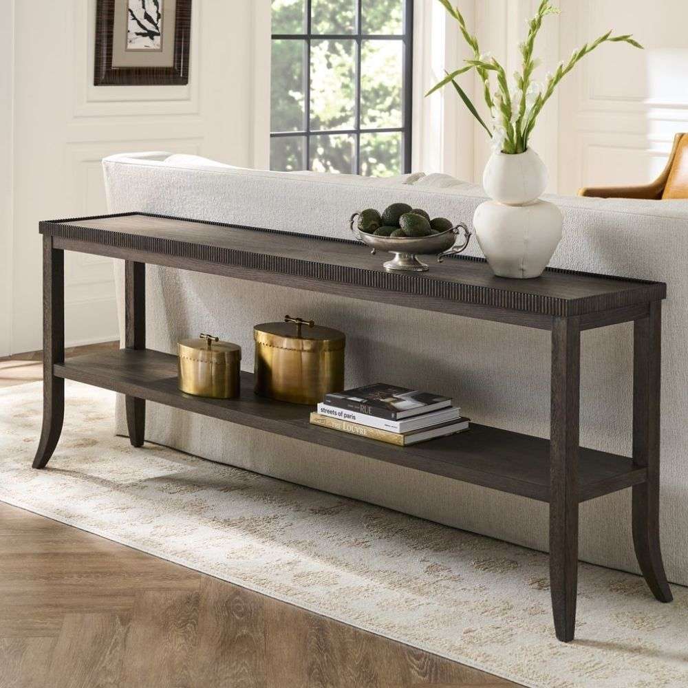 Long wooden console table with a lower shelf, curved legs, and detailed edge trim in a warm medium wood finish.