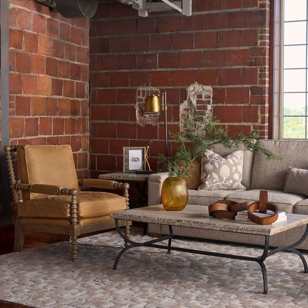 Leather accent chair with a warm tan cushion and back, featuring a solid wood frame with turned spindle detailing on the arms and legs.