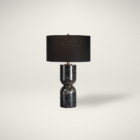 Sculptural black marble table lamp with black fabric shade shown against a neutral background.
